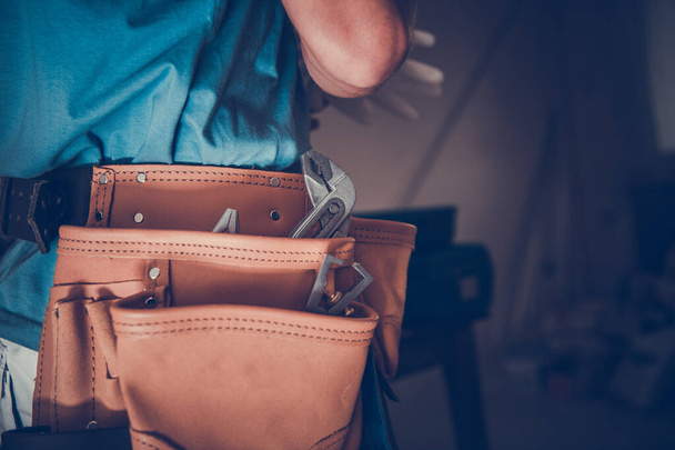 Closeup of Beautifully Made Leather Tool Belt in Use by a Contractor During Residential Building Renovation Work. Construction Site in the Background. - 写真・画像