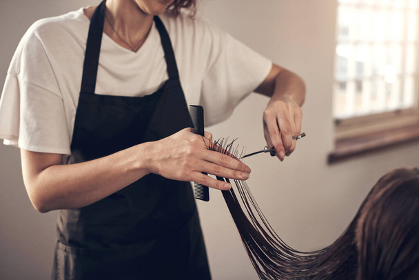 Theres nothing good hands and a pair of good scissors cant fix. a hairstylist cutting a clients hair in a salon - Foto, imagen