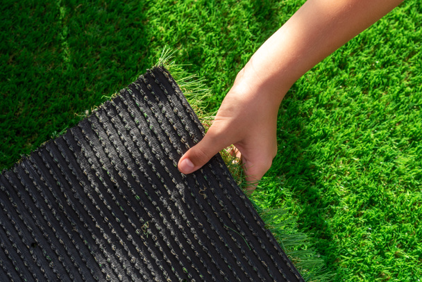 Close-up of the back of a roll of artificial turf. Synthetic artificial grass material easy to install and maintain - Photo, Image