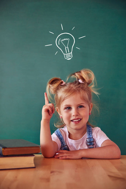 School child (girl) in classroom. Funny kid against green chalkboard. Idea and creativity concept. Copyspace on background. Back to school concept.  - Foto, Imagen