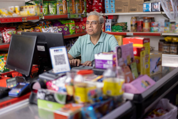 Šťastný muž pracující jako pokladní v supermarketu - Fotografie, Obrázek