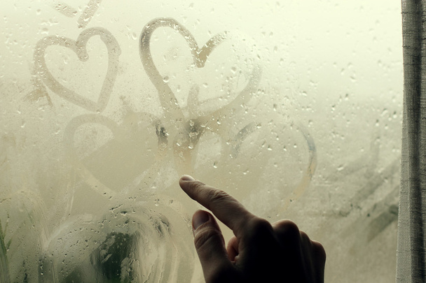 Nainen piirtämässä sydämiä ikkunaan
 - Valokuva, kuva