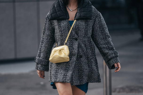 Milan, Italy - February, 24: Street style, woman wearing yellow shiny leather crocodile bag, blue dress and orange shoes. - Foto, afbeelding