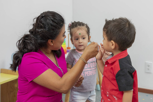 Nurse placing a star on a childs forehead for good behavior in her office. - Foto, imagen
