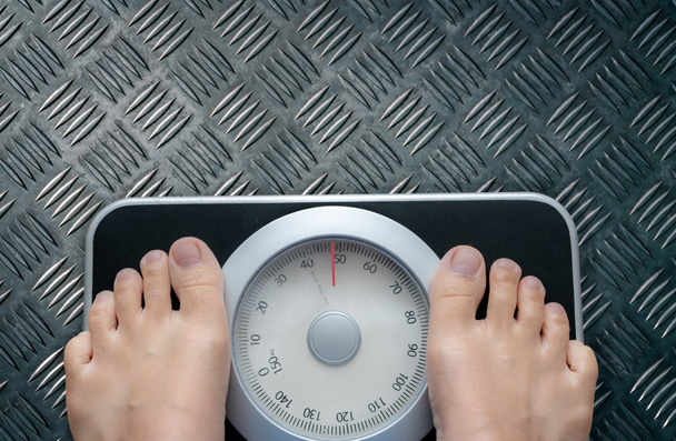 Top view of feet on weighing scale. Women weigh on a weight balance scale after diet control. Healthy body weight. Weight and fat loss concept. Weight measure machine. Body Mass Index or BMI concept. - Fotoğraf, Görsel