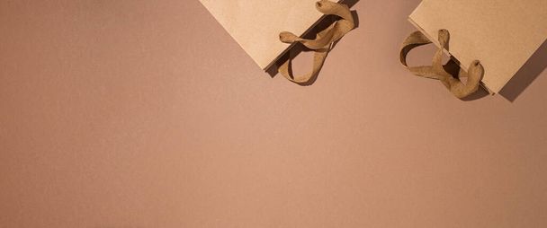 Imballaggio confezioni regalo kraft marrone su uno sfondo di cartone marrone. Vista dall'alto, posizione piatta. Bandiera.  - Foto, immagini