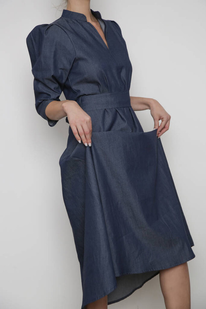 Serie van studio foto 's van jonge vrouwelijke model dragen bladerdeeg mouwen katoen denim jurk - Foto, afbeelding