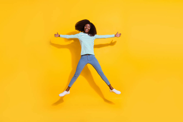 Full body photo of overjoyed satisfied person jumping raise hands make star figure isolated on yellow color background. - Фото, зображення