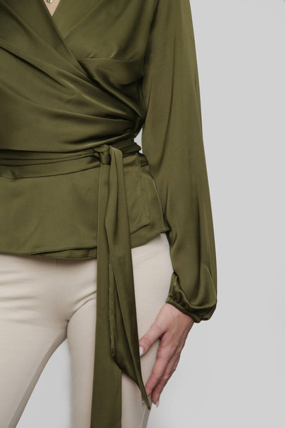 Serie of studio photos of young female model wearing green silk blouse and basic beige flared trousers - Fotografie, Obrázek