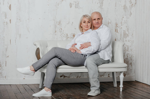 mężczyzna i jego żona w białych koszulach na kanapie - Zdjęcie, obraz