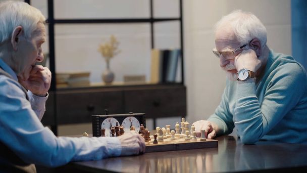 pensive senior man playing chess with friend at home - Foto, Imagem