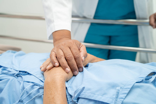Holding hands Asian senior or elderly old lady woman patient with love, care, encourage and empathy at nursing hospital ward, healthy strong medical concept - Фото, зображення