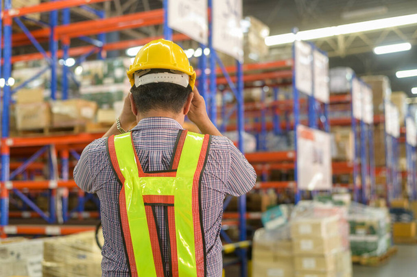 A Portrait of senior asian male worker wearing helmet in modern warehouse storage of retail shop - Foto, Imagem