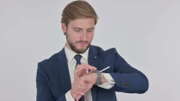 Νεαρός ενήλικος επιχειρηματίας που χρησιμοποιεί SmartWatch σε λευκό φόντο  - Πλάνα, βίντεο
