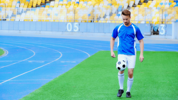 young and sportive football player bouncing soccer ball with legs - Φωτογραφία, εικόνα