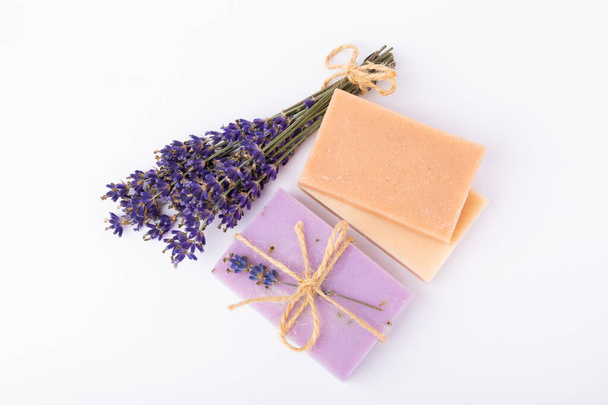 Handmade soap with lavender isolated on white background.Lavender spa. Lavender flowers and handmade soap. Natural herbal cosmetics with lavender flowers on a marble background.Copy space.Fletley - Foto, Imagen