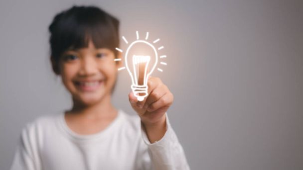Smart child girl with light bulb idea concept. school concept. - Valokuva, kuva