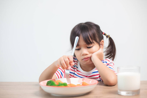 Odżywianie i zdrowe nawyki żywieniowe dla dzieci koncepcji. Dzieci nie lubią jeść warzyw. Little cute dziewczyna odmawia jedzenia zdrowych warzyw. - Zdjęcie, obraz