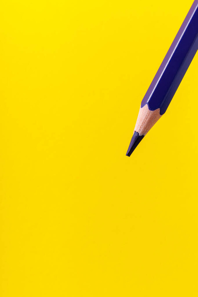 Kleurpotlood close-up met selectieve focus op de stylus en een wazige gele achtergrond. Kopieer ruimte voor tekst. - Foto, afbeelding