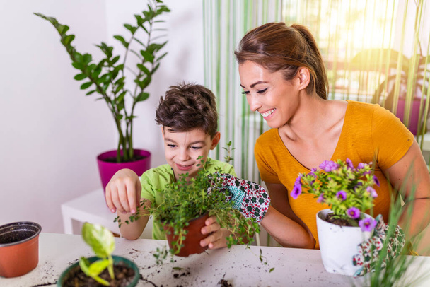 Mom and boy child water the plants together, Mom's little gardener assistant, taking care of children and flowers. Cute boy watering from watering can, take care of trees and plants, wet child - Φωτογραφία, εικόνα