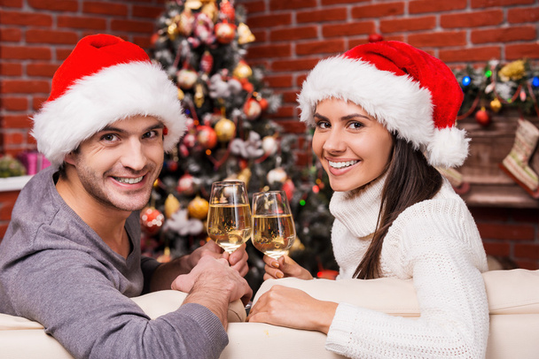 Couple in Santa hats drinking wine on Christmas - Φωτογραφία, εικόνα