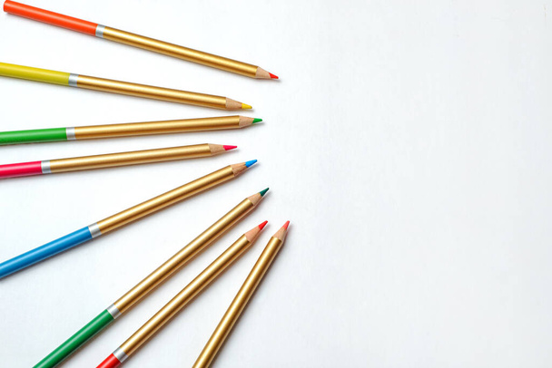 Gekleurde potloden wanordelijk op witte achtergrond. Groep potloden van verschillende kleuren. - Foto, afbeelding