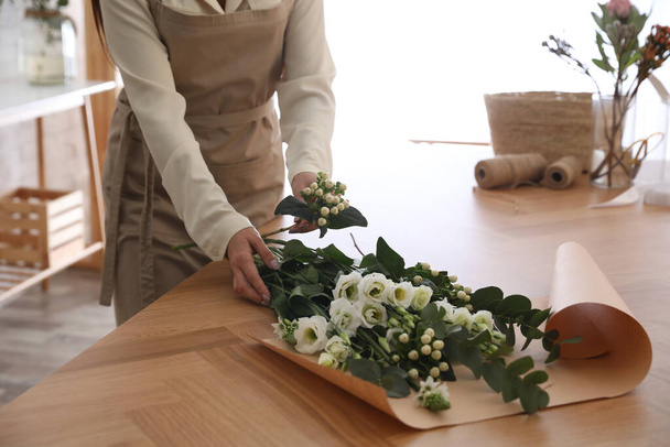 Florist making beautiful bouquet at table in workshop, closeup - Photo, Image