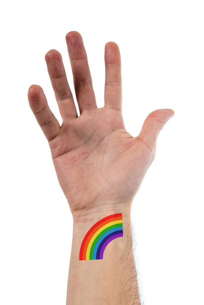 Beautiful and stylized open hand of caucasian person with a big tattoo of LGBTQ rainbow of pride over 100% white background - 写真・画像