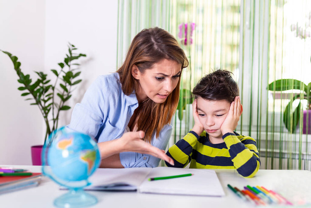 Stressed mother and son frustrated over failure homework, school problems concept. Sad little boy turned away from mother, does not want to do boring homework - Foto, imagen