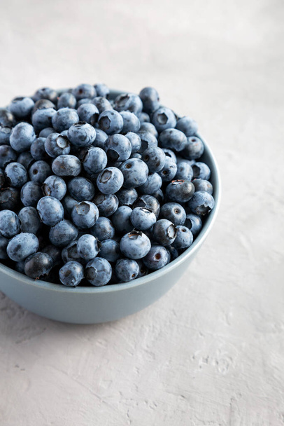 Raw Organic Blueberries in a Bowl on a gray background, side view.  - Photo, image