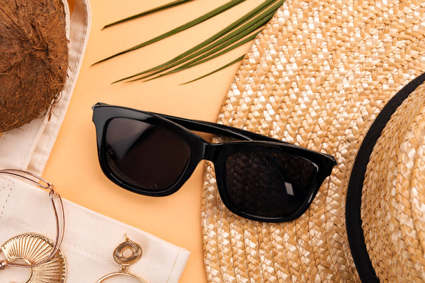 New stylish sunglasses, jewelry and straw hat on beige background, flat lay - Foto, Imagem