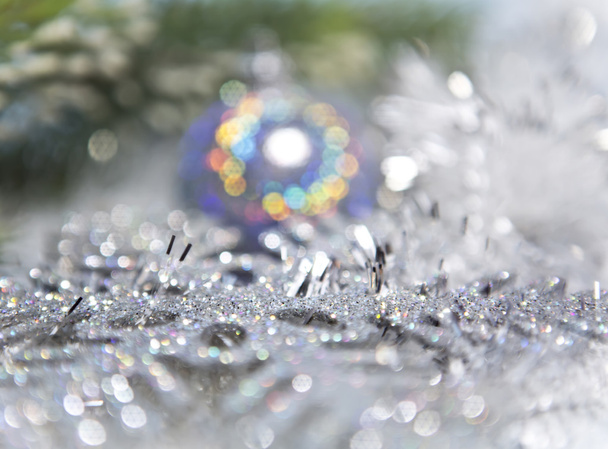 Decorative New Year's background - tinsel and a ball out of focus - Photo, Image