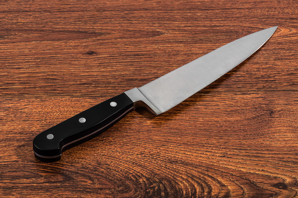 Кухонный нож на деревянном столе
 - Фото, изображение