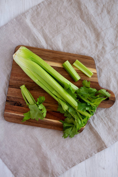 Raw Organic Celery on a wooden board, top view. Flat lay, overhead, from above. - Foto, afbeelding