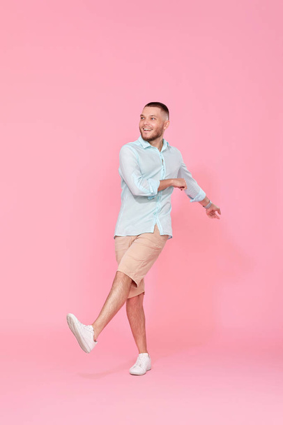 cheerful young happy man dance on pink background. vacation summer. Full body - Fotografie, Obrázek