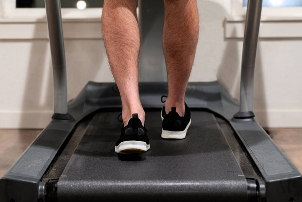 A man exercising while walking or running on a treadmill - 写真・画像