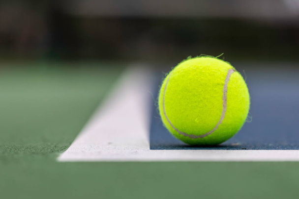 Teniszlabda a földön, a pálya vonalain belül. - Fotó, kép