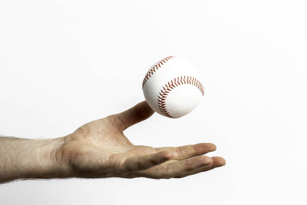 A baseball being tossed from a hand on a white background - Fotoğraf, Görsel