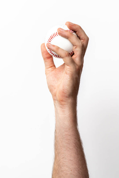 Egy baseball labdát dobnak ki egy kézből, fehér alapon. - Fotó, kép