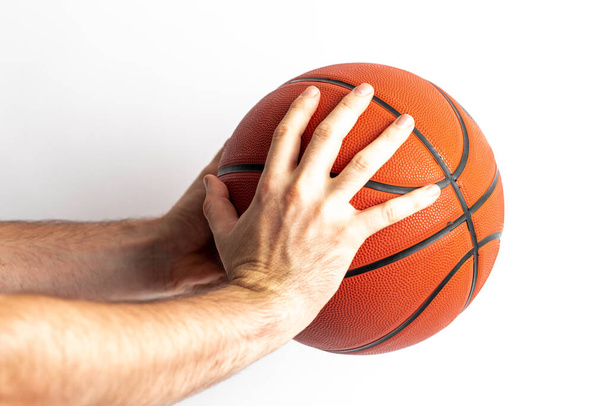 Чоловік тримає баскетбол в руці на білому тлі
 - Фото, зображення