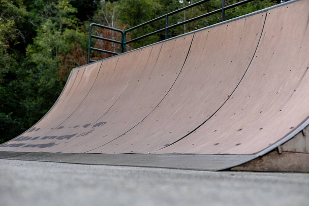 A quarter pipe ramp at a skate park for board sports - Фото, изображение
