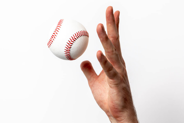 A baseball being tossed from a hand on a white background - Фото, изображение
