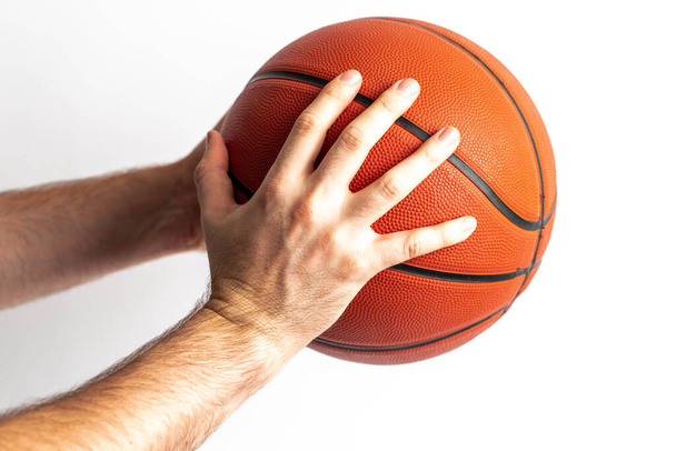 Beyaz arka planda elinde basketbol topu tutan bir erkek. - Fotoğraf, Görsel