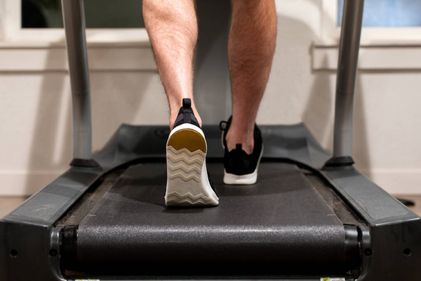 A man exercising while walking or running on a treadmill - Fotó, kép