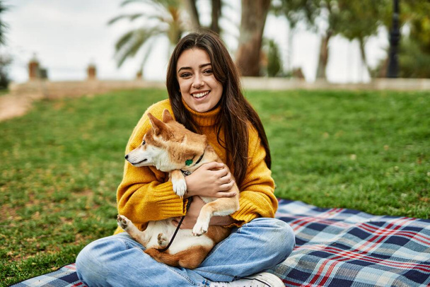 Kaunis nuori nainen halaus onnellinen shiba inu koira puistossa - Valokuva, kuva