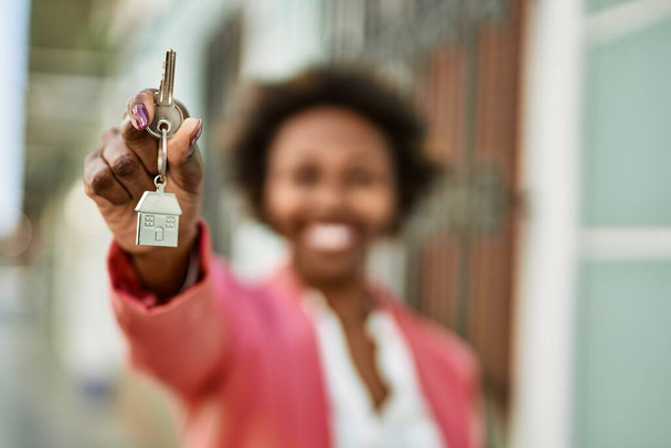 Genç Afro-Amerikalı kadın elinde anahtar tutuyor. - Fotoğraf, Görsel