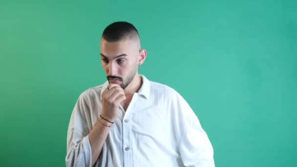 Man gesturing overthinking, young male overthinking facial expression, image of emotions and facial expressions taken in front of the green curtain - Filmati, video