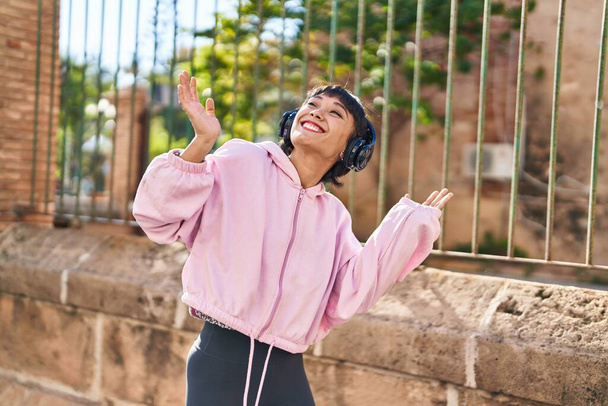 Jeune femme écoutant de la musique et dansant dans la rue - Photo, image