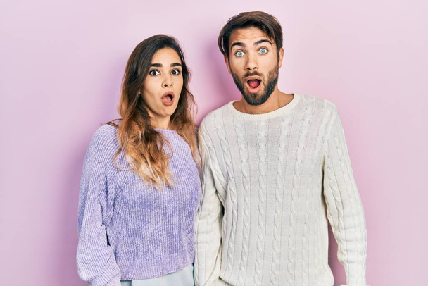 Young hispanic couple wearing casual clothes afraid and shocked with surprise and amazed expression, fear and excited face.  - Foto, imagen