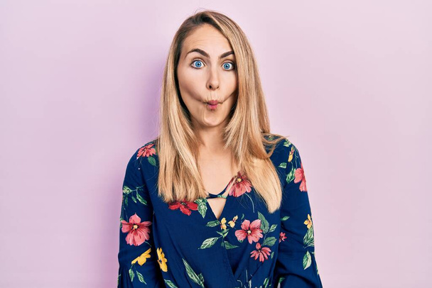Young caucasian woman wearing casual clothes making fish face with lips, crazy and comical gesture. funny expression.  - Photo, Image